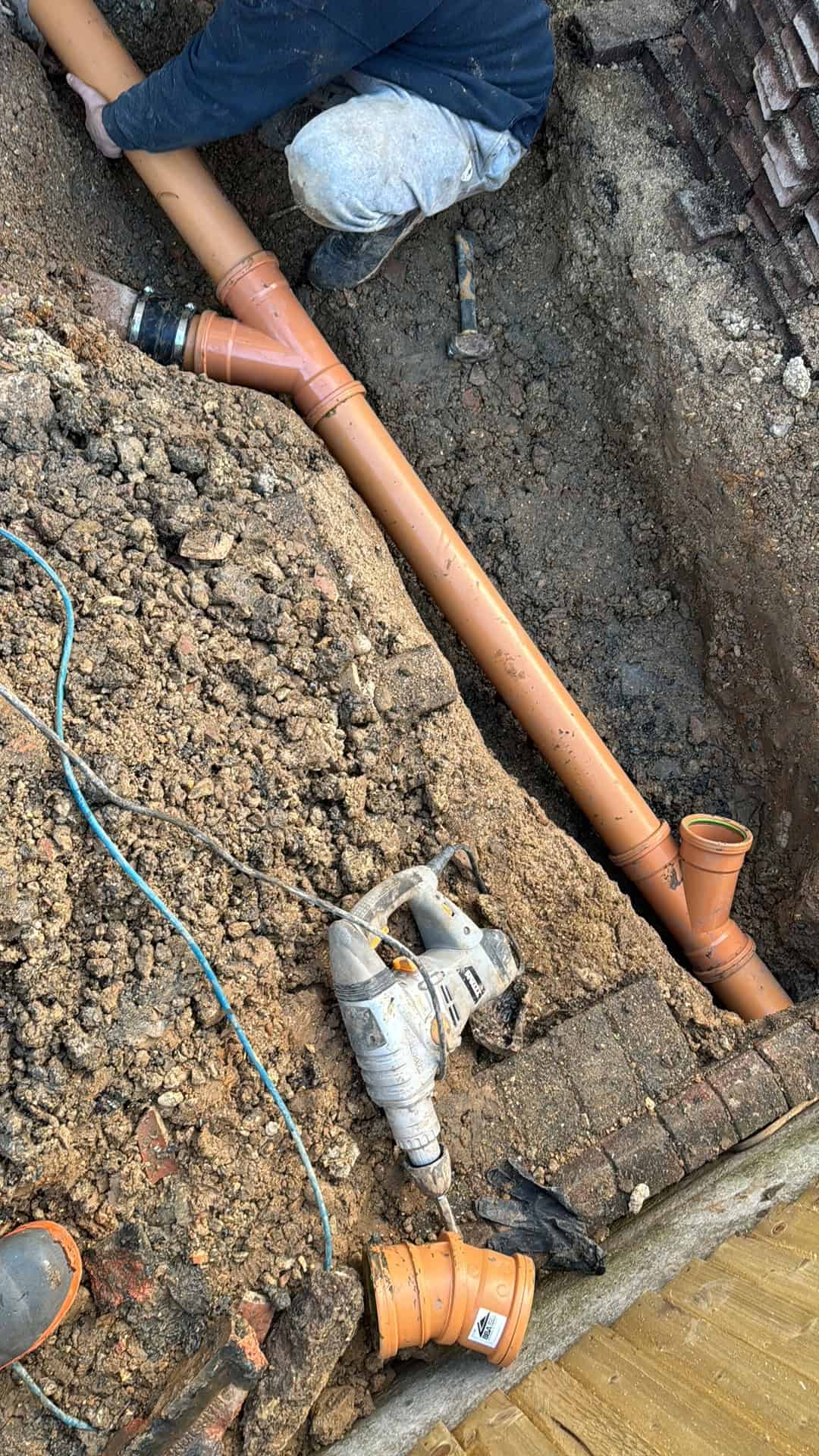 Installing a drainage pipe in a trench for effective water management.